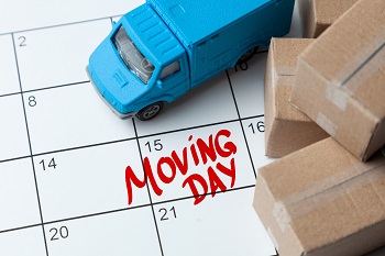 Moving day on the calendar is written in red. Calendar with a note with cardboard boxes and truck, office moving